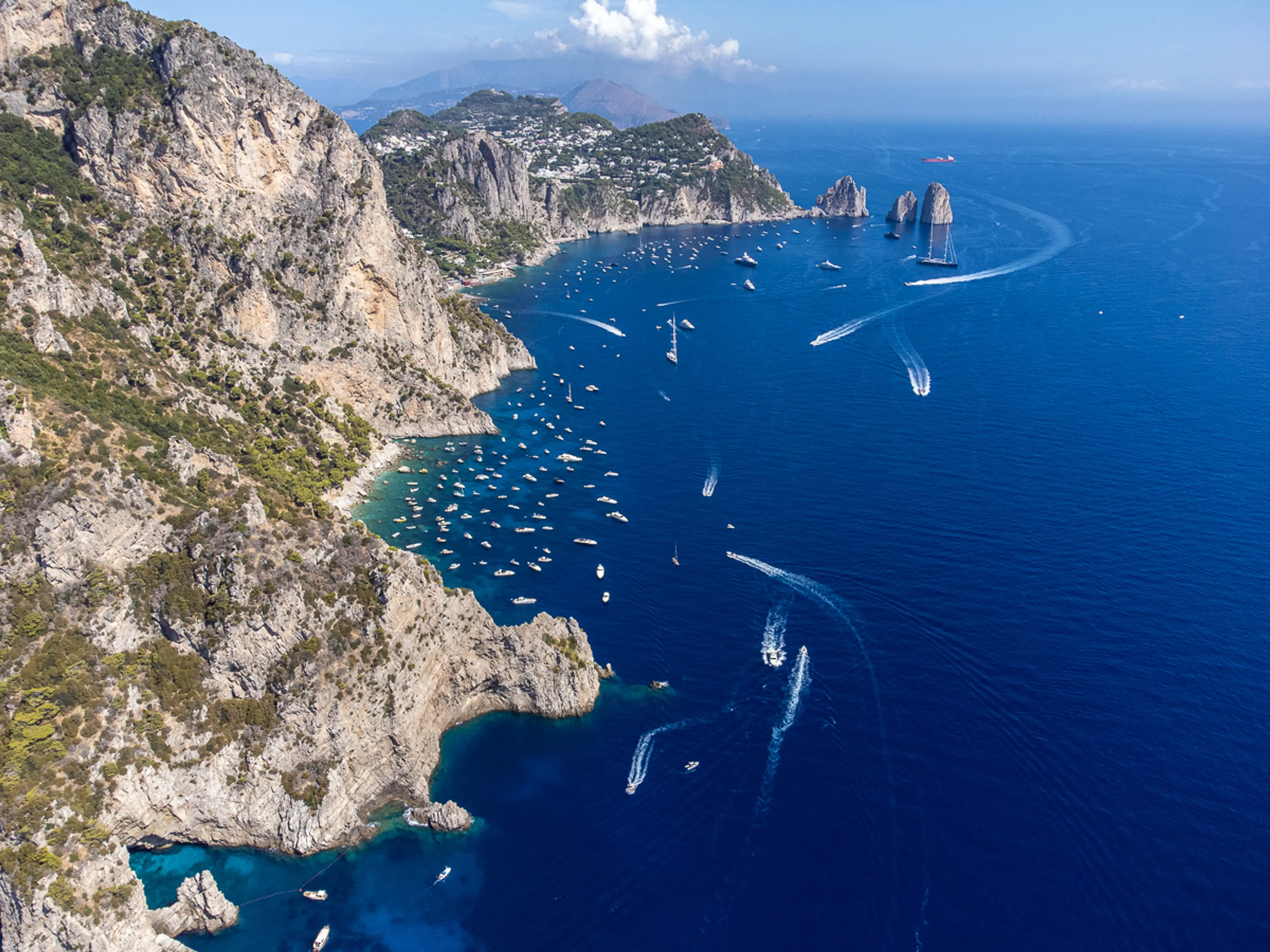 Caletta turchese circondata da scogliere lungo la costa di Capri