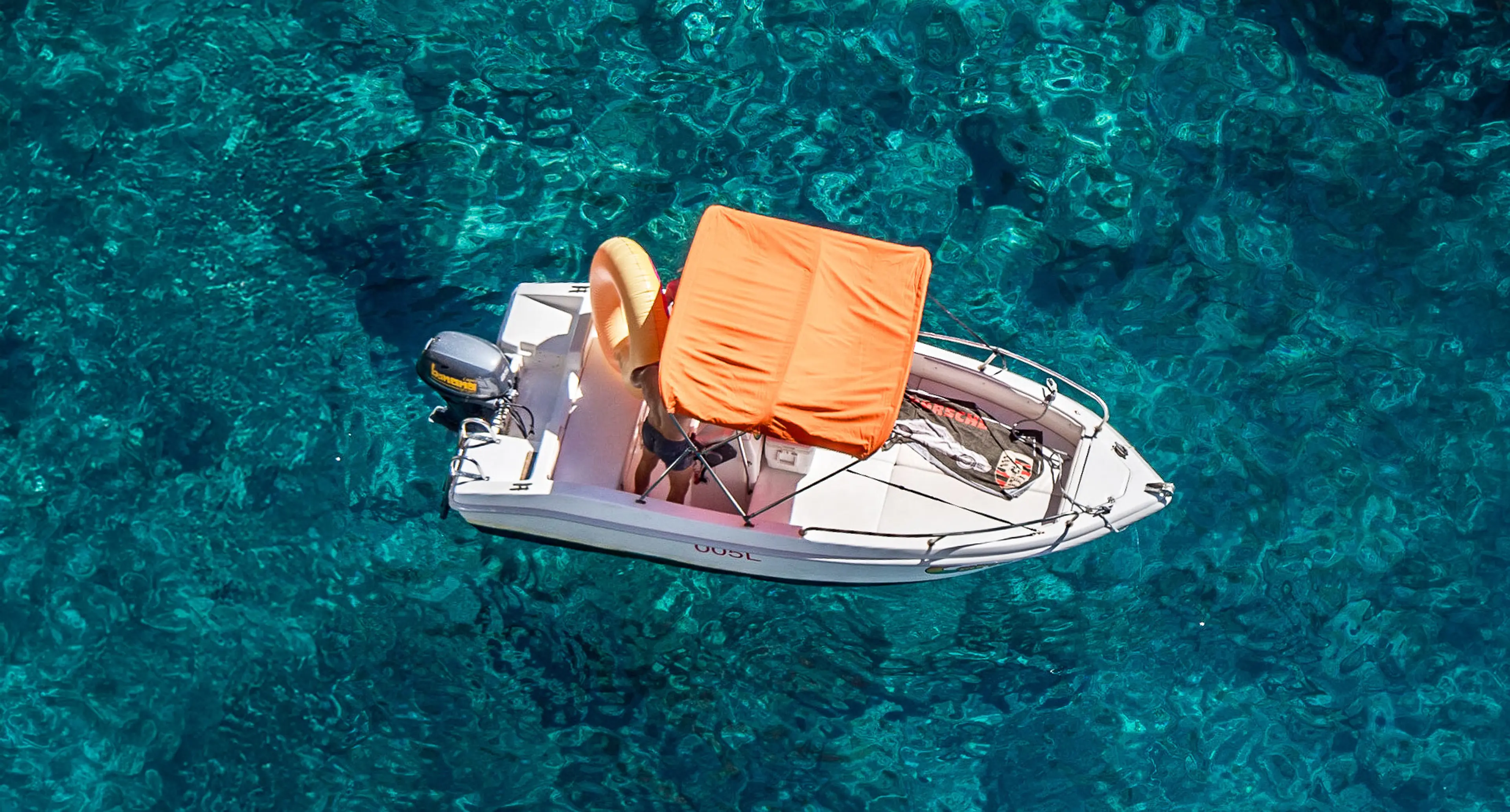 Barca open Banana Sport con cuscini arancioni sull'acqua turchese di Capri