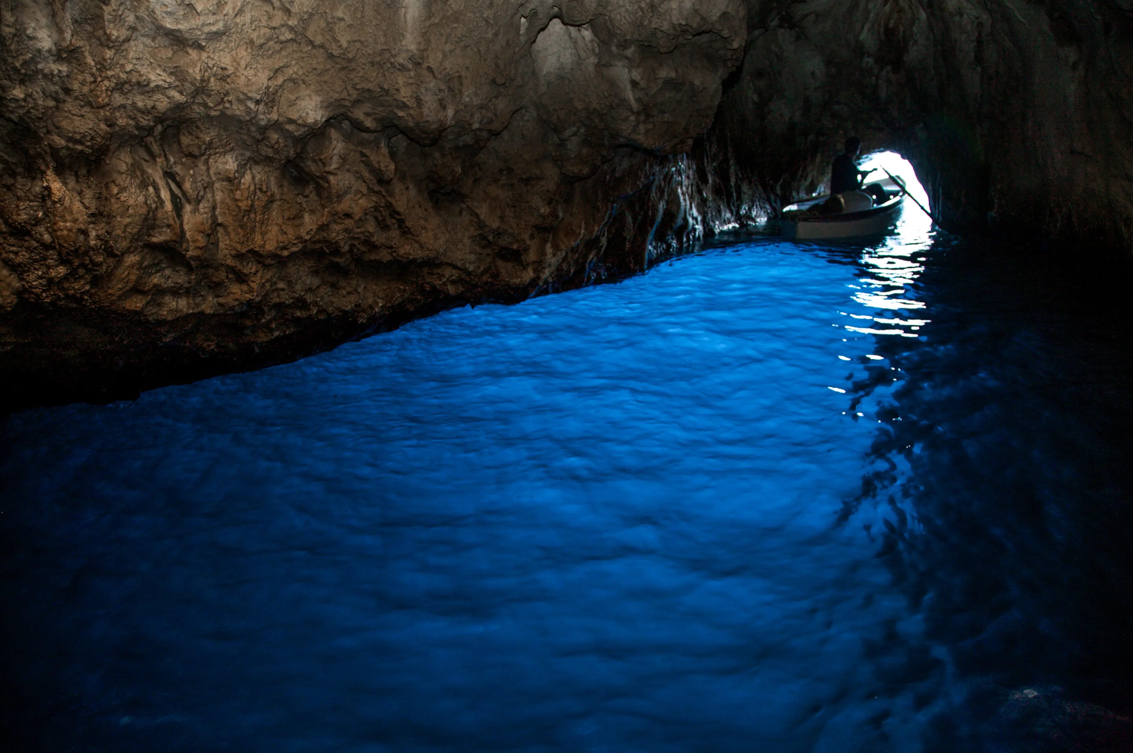 Luce azzurra intensa all'interno della Grotta Azzurra di Capri vista dalla barca