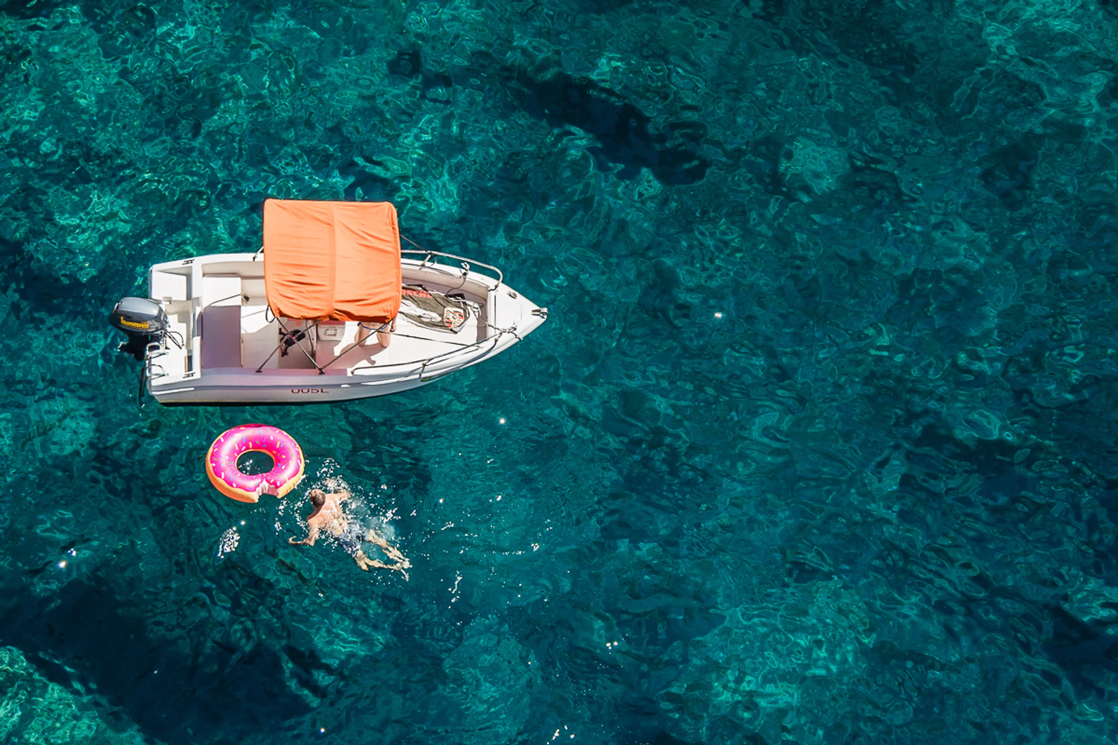 Barca open con cuscini arancioni ormeggiata sull'acqua turchese a Capri