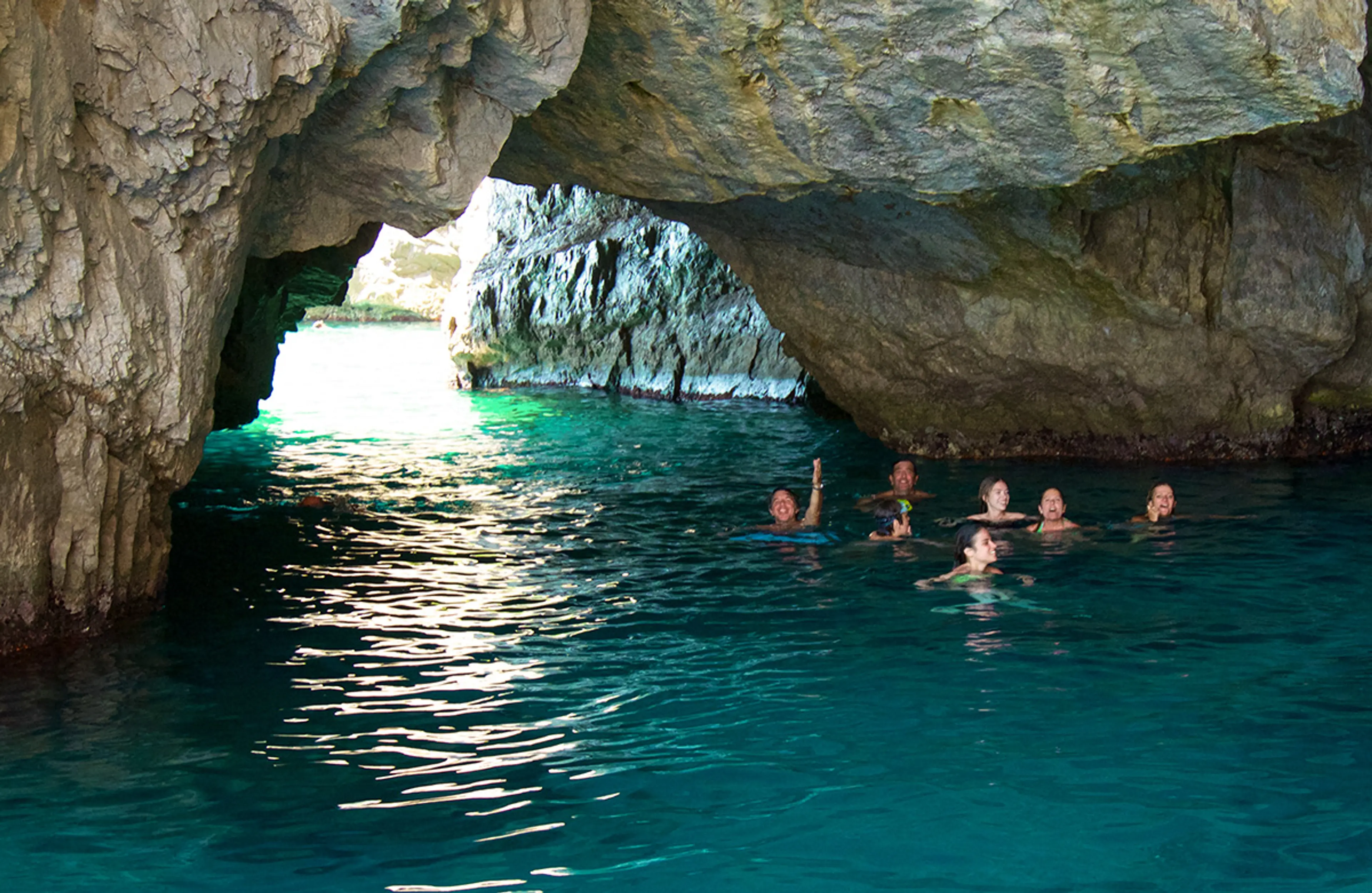 Ampio ingresso di grotta con acqua smeraldo lungo la costa di Capri