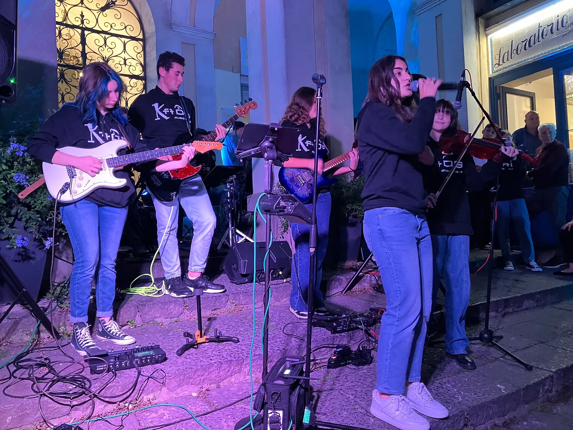 Allievi con chitarra, basso e violino durante un concerto