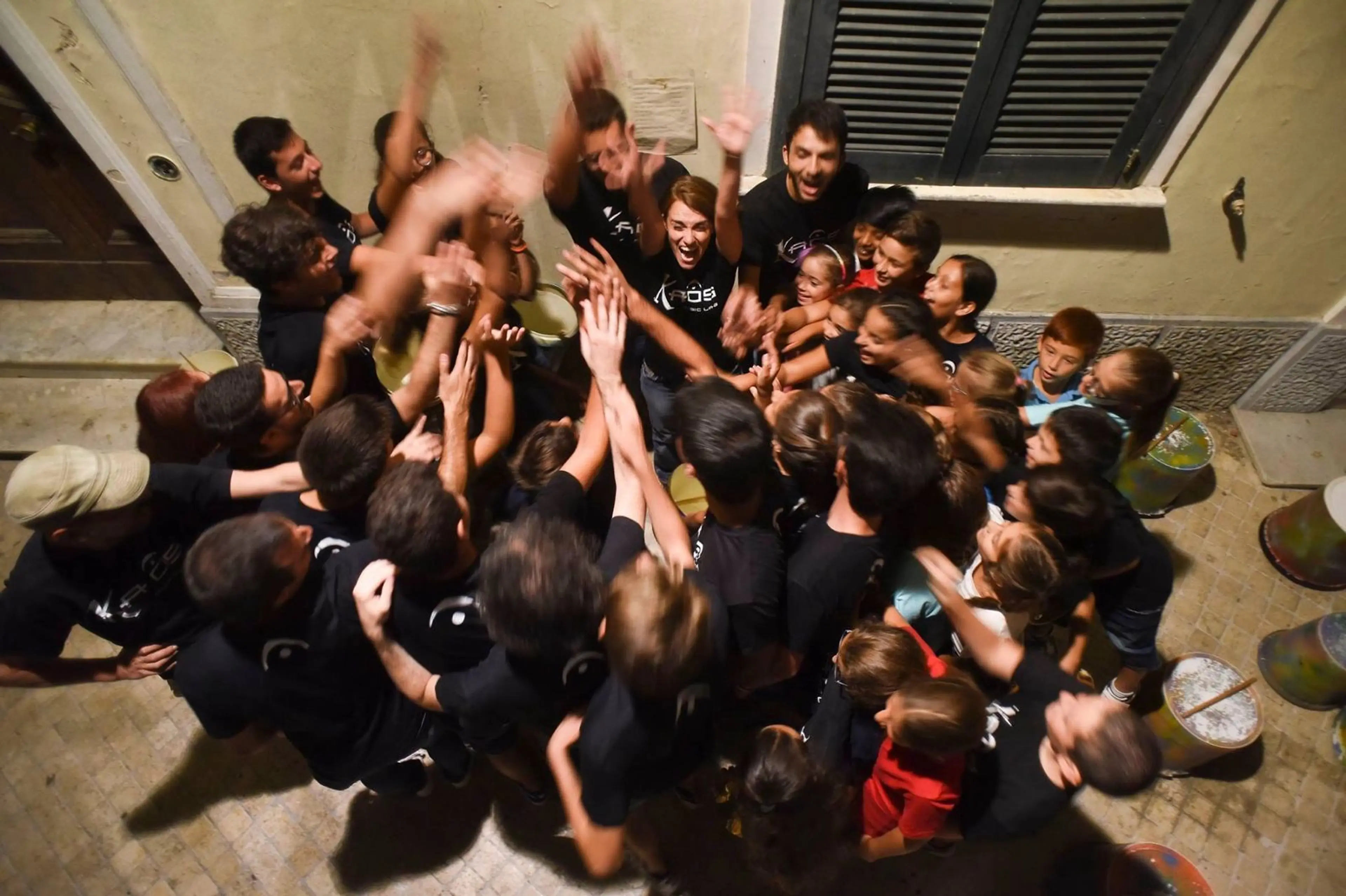 Ragazzi di Kaos Music Lab festeggiano insieme con le braccia alzate