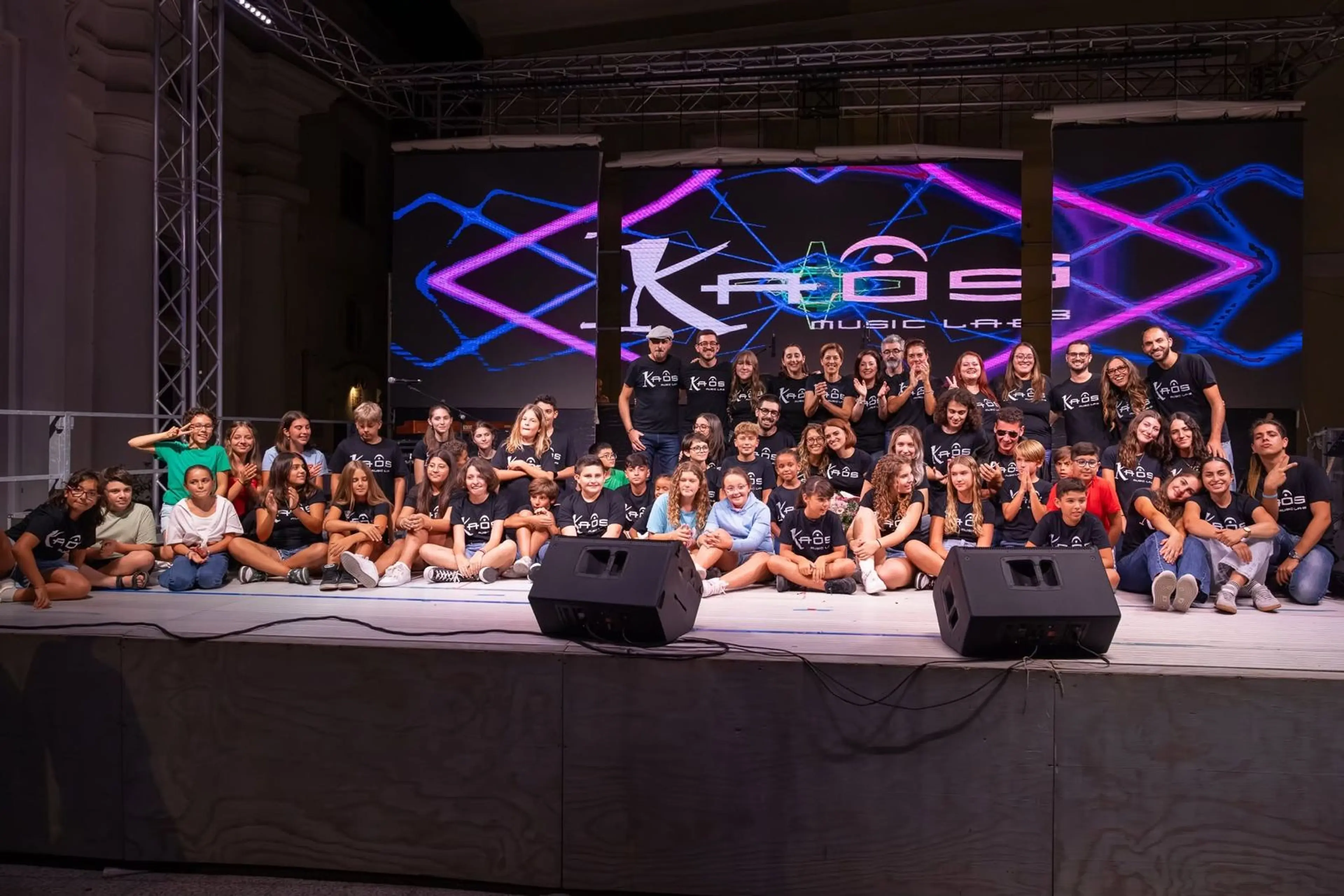 La comunità di Kaos Music Lab riunita sul palco con allievi e insegnanti