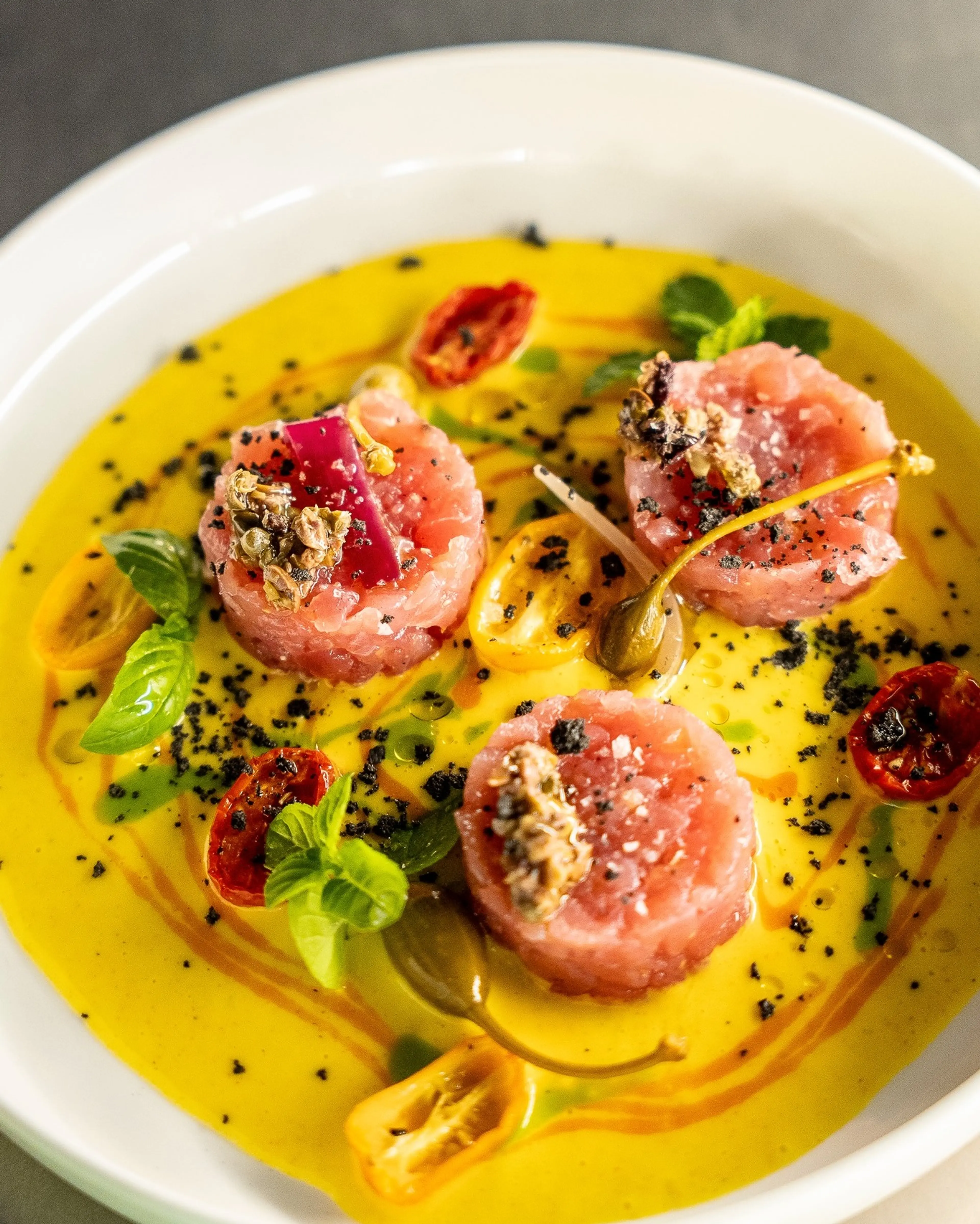 Tuna tartare with saffron sauce and confit tomatoes