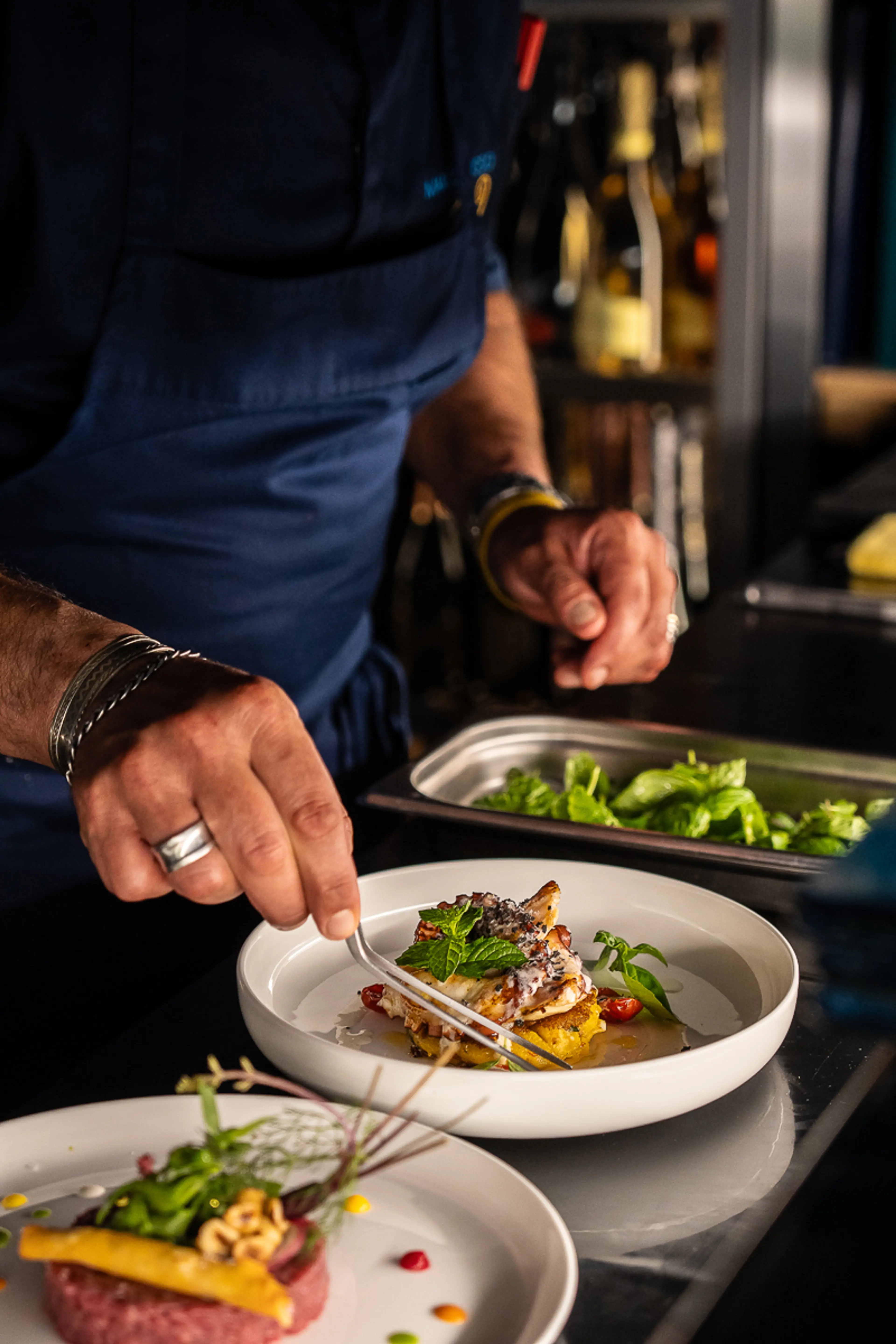 Chef Marco Russo plating a fish course
